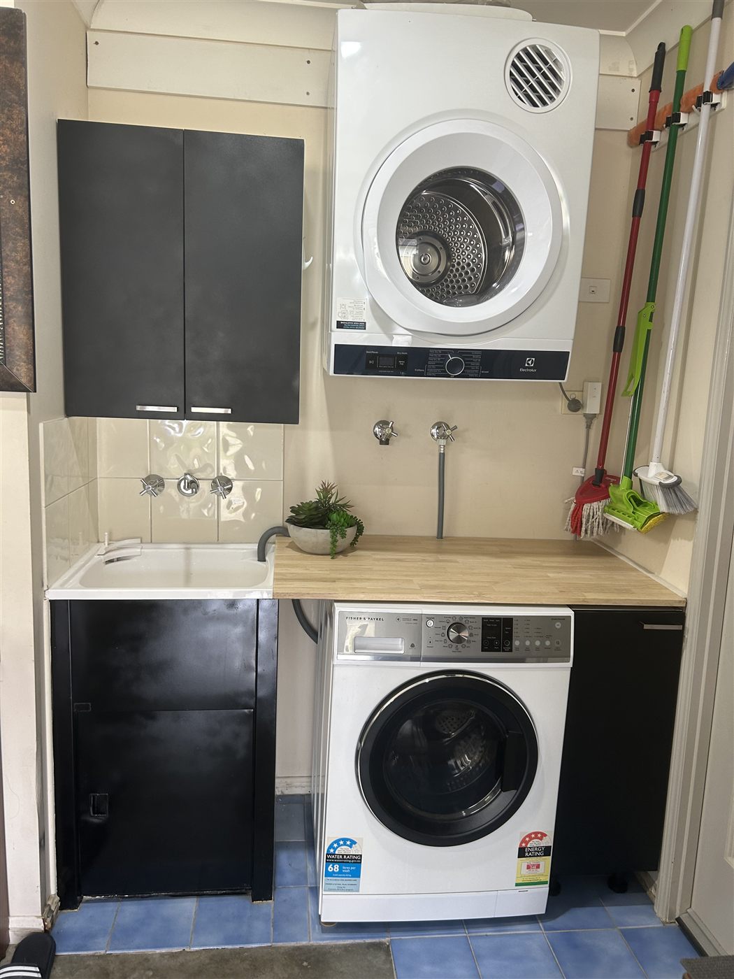 Renovated laundry with black cabinetry and timber benchtop