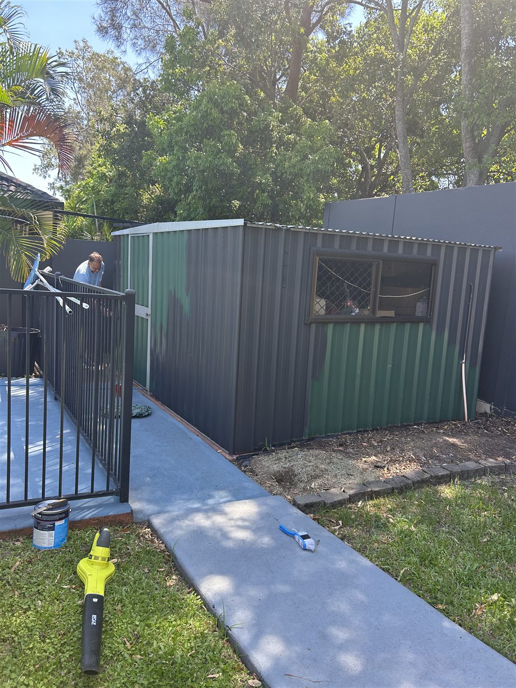 Old green garden shed mid-repaint